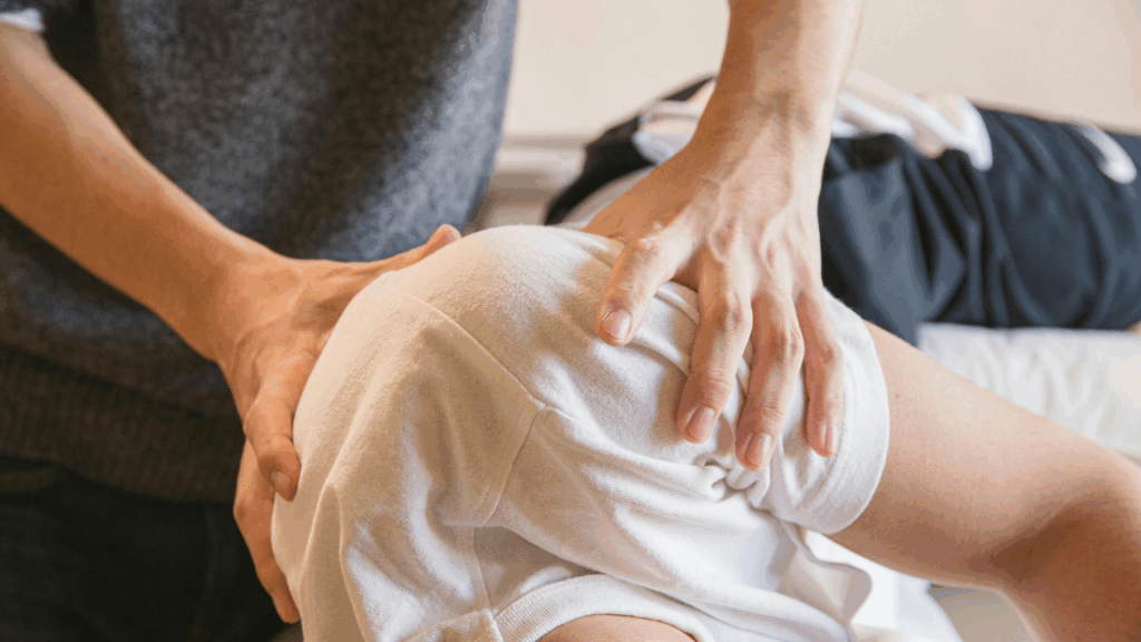 A chiropractor’s hands performing a pelvic adjustment on a patient to demonstrate the Drop Table Adjustments technique at Spine and Joint Center in Fort Lauderdale.