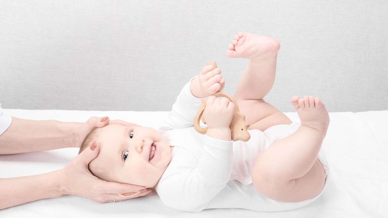 A chiropractor’s hands performing a gentle cranial and upper cervical assessment on an infant to represent the specialized infant chiropractic care provided at Spine and Joint Center in Fort Lauderdale.