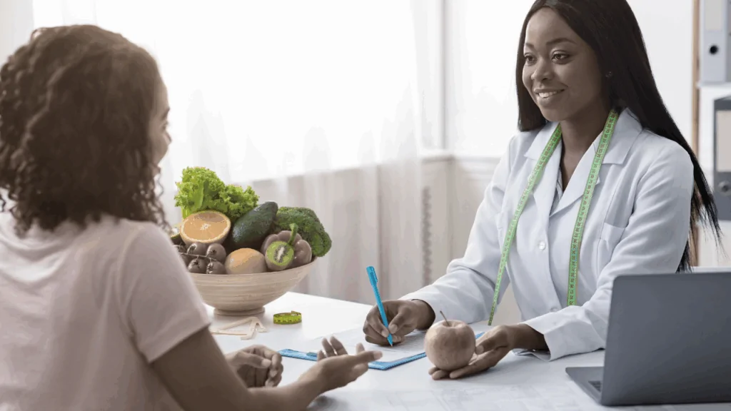 A professional nutritionist in a white coat consulting with a patient about healthy food choices to provide specialized chiropractic nutritional counseling in Fort Lauderdale.
