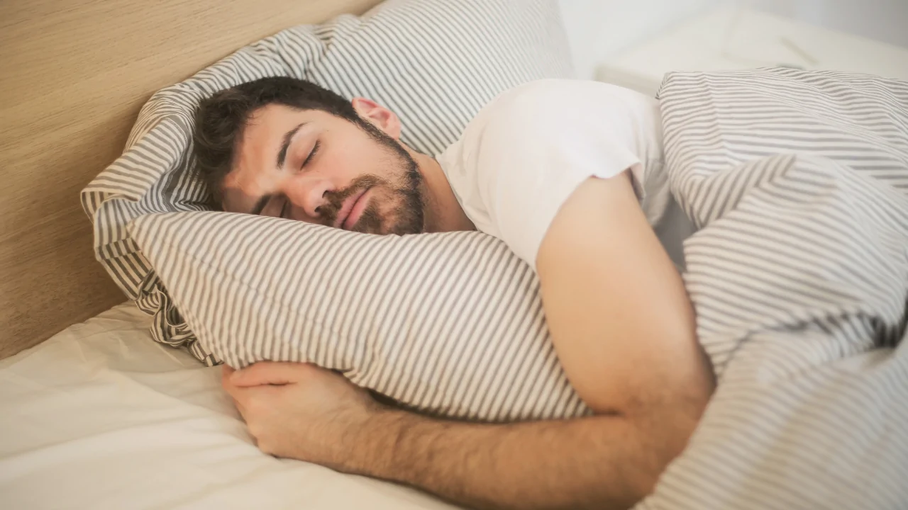 A man sleeping comfortably on a supportive pillow to demonstrate the results of professional sleep optimization chiropractic care in Fort Lauderdale.