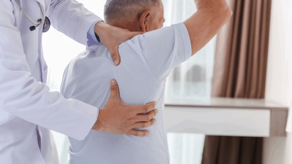 A chiropractor in a white lab coat with a stethoscope around their neck performing a specialized upper back and shoulder mobilization on an adult patient to provide growing pains treatment at Spine and Joint Center in Fort Lauderdale.