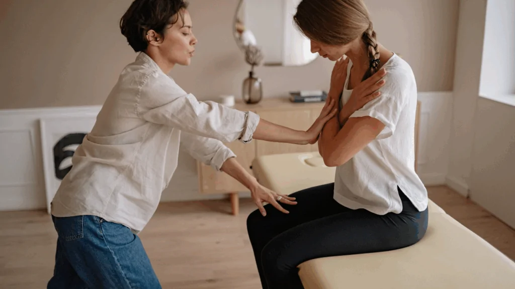 A health coach guiding a seated patient through postural correction exercises to provide specialized holistic lifestyle coaching in Fort Lauderdale.