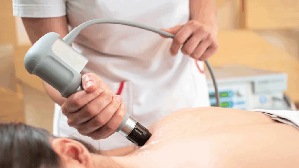 A clinician using a specialized handheld therapeutic device on a patient’s back to provide supportive care for Multiple Sclerosis at Spine and Joint Center in Fort Lauderdale.