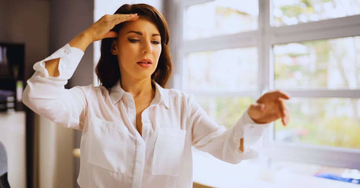 A woman experiencing dizziness and holding her head, illustrating the need for professional vertigo and balance issue care in Fort Lauderdale.