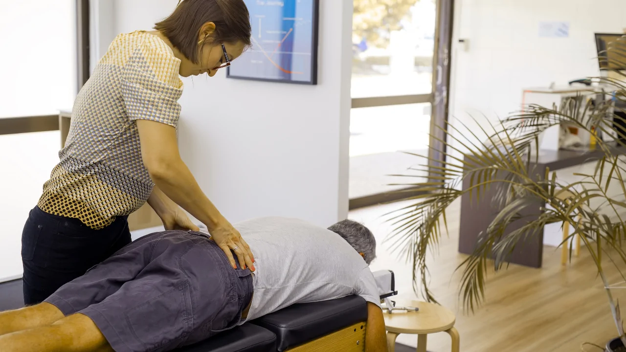 A chiropractor performing a manual lumbar adjustment on a patient to provide routine wellness chiropractic adjustments in Fort Lauderdale.
