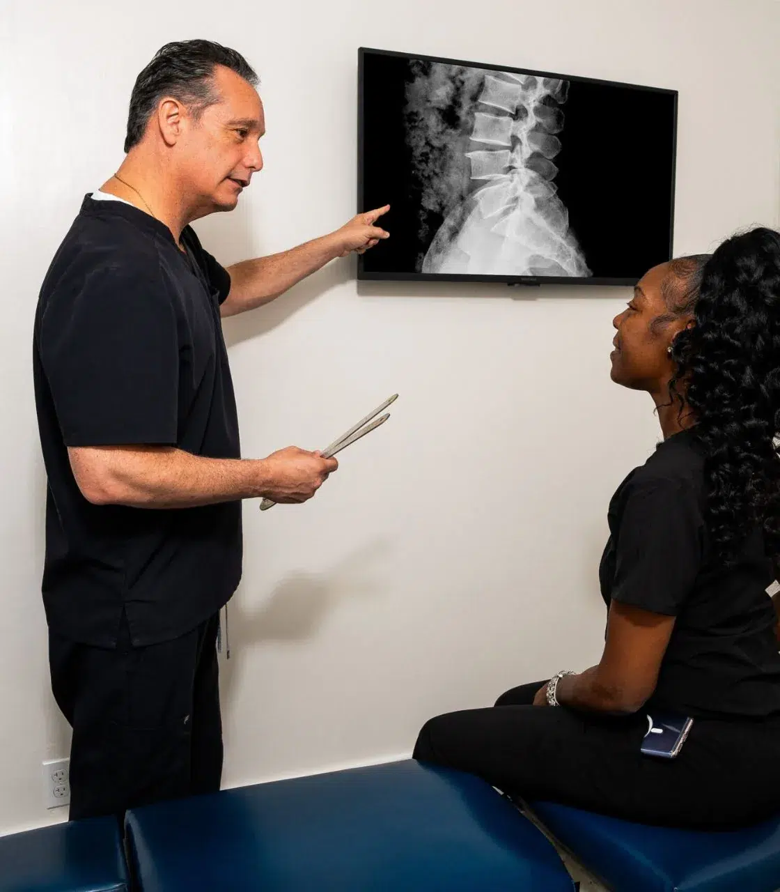 Dr. Douglas Kellerman DC reviewing lumbar spine X-ray with patient at Spine and Joint Center Fort Lauderdale